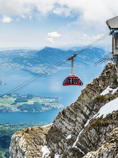 Cable car ascending from Kriens to Mount Pilatus with scenic view of Lake Lucerne.