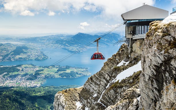 Cable car ascending from Kriens to Mount Pilatus with scenic view of Lake Lucerne.