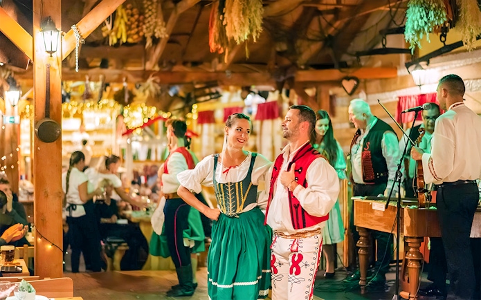 Prague folklore dinner show with dancers in traditional costumes and live musicians.