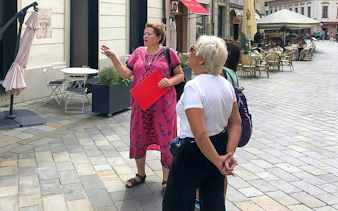Tour guide leading a group through Bratislava's historic streets.