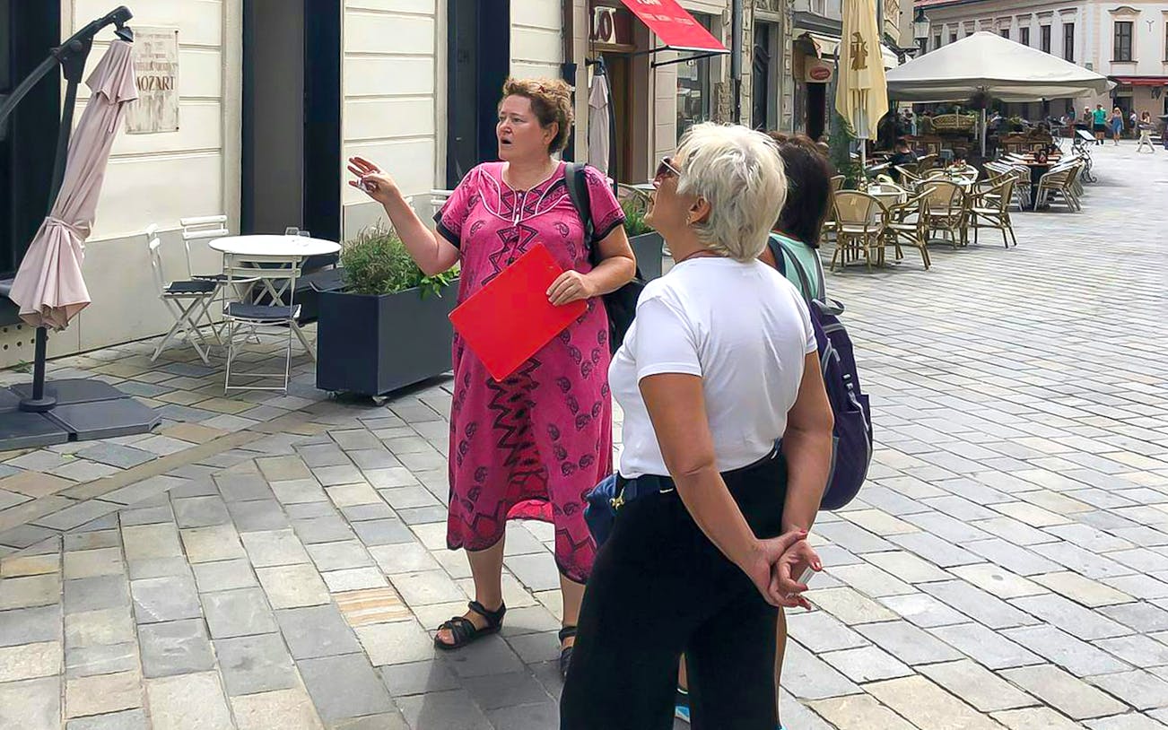 Tour guide leading a group through Bratislava's historic streets.