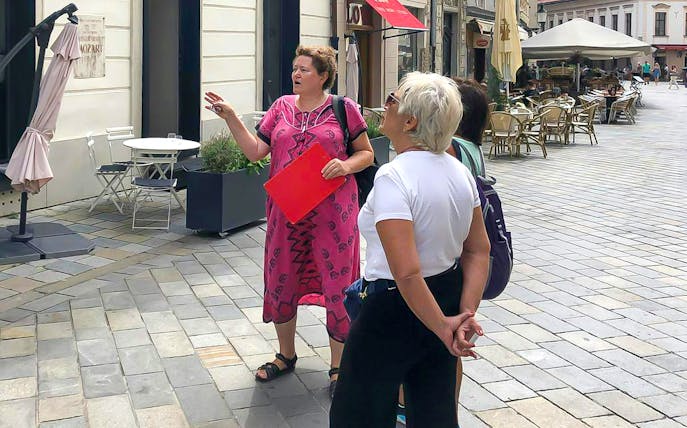 Tour guide leading a group through Bratislava's historic streets.