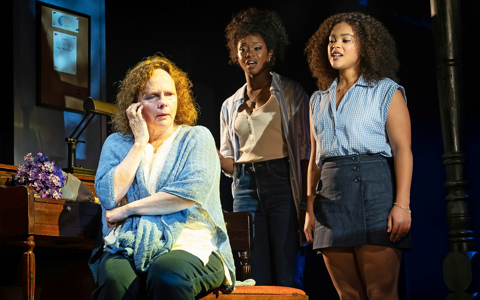 Three actors perform a scene from "The Notebook" musical on stage.