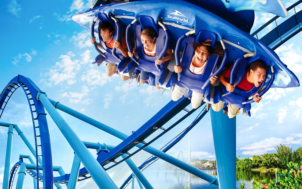 Riders on Manta roller coaster at SeaWorld, Orlando, experiencing a thrilling loop.