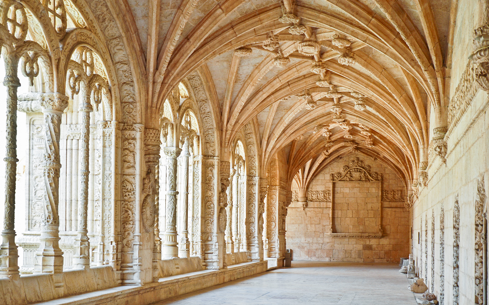 Jernimos Monastery interior with ornate arches and detailed stone carvings in Lisbon, Portugal.