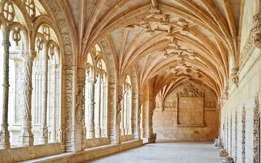 Jernimos Monastery interior with ornate arches and detailed stone carvings in Lisbon, Portugal.