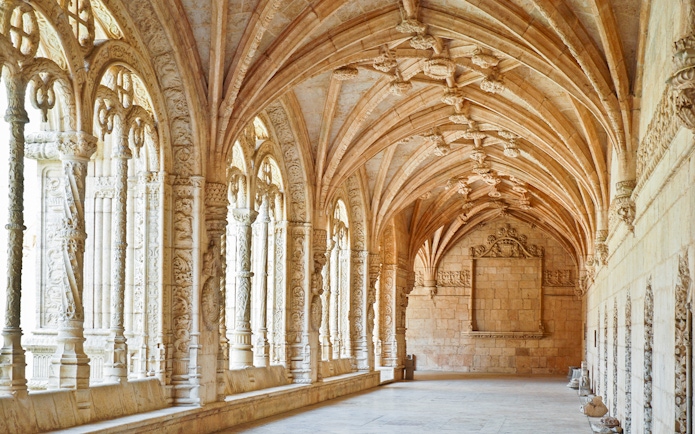 Jernimos Monastery interior with ornate arches and detailed stone carvings in Lisbon, Portugal.