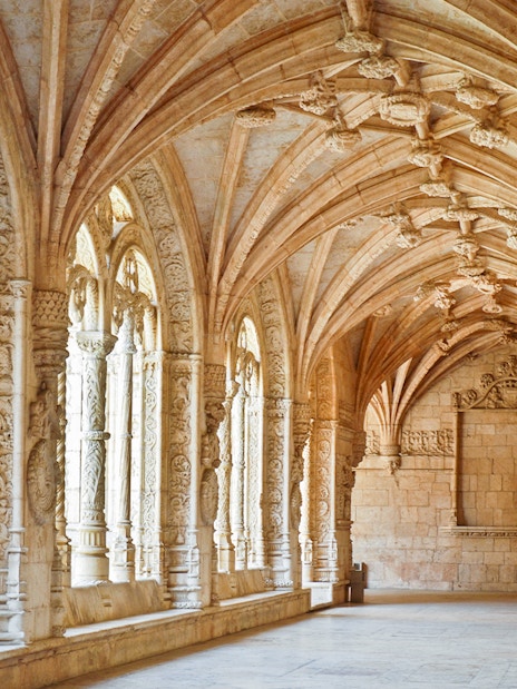 Jernimos Monastery interior with ornate arches and detailed stone carvings in Lisbon, Portugal.