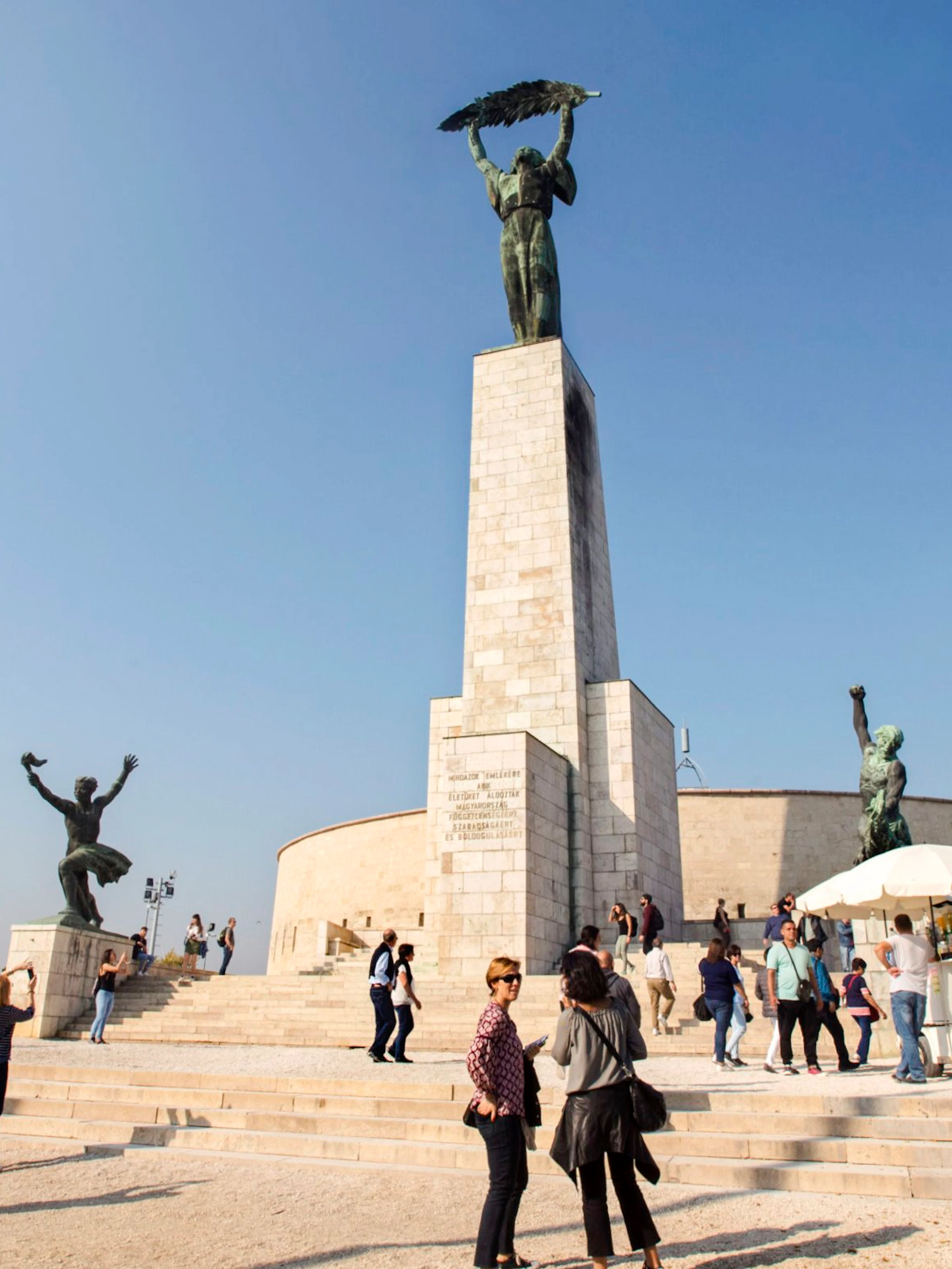 Liberty Statue on Gellert Hill with visitors, Budapest, Hungary.