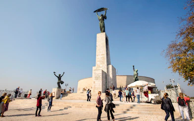 Liberty Statue on Gellert Hill with visitors, Budapest, Hungary.