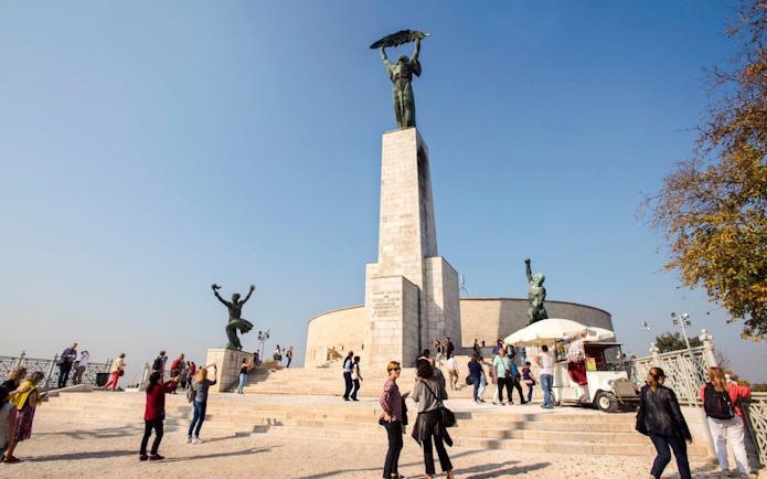 Liberty Statue on Gellert Hill with visitors, Budapest, Hungary.