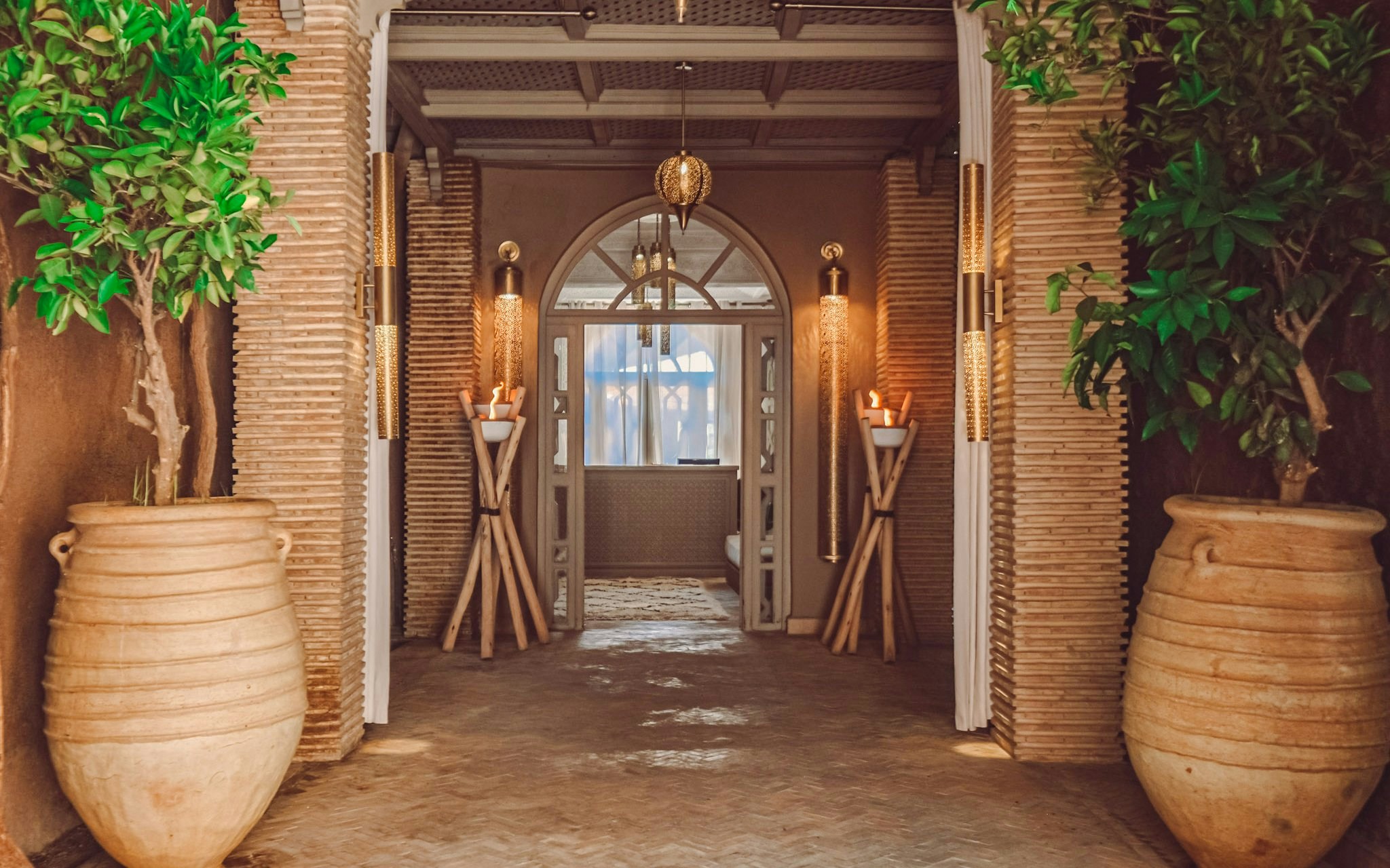 Luxury steam hammam entrance with ornate lighting and large potted plants.