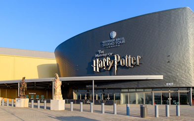 Warner Bros. Studio Tour London entrance with Harry Potter-themed statues.
