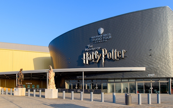 Warner Bros. Studio Tour London entrance with Harry Potter-themed statues.