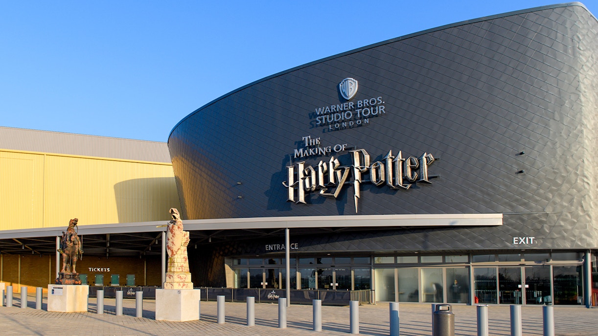 Warner Bros. Studio Tour London entrance with Harry Potter-themed decorations and visitors exploring.