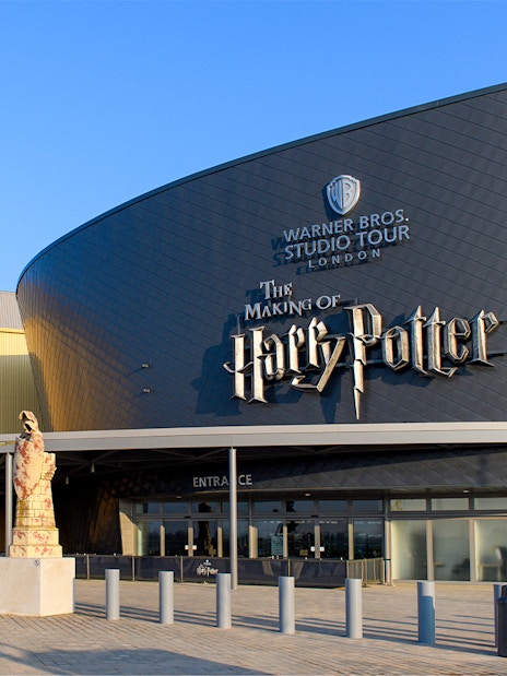 Warner Bros. Studio Tour London entrance with Harry Potter-themed statues.