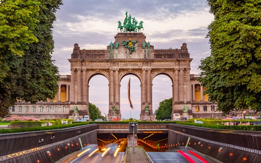 Triumphal Arch at Parc du Cinquantenaire in Brussels at dusk with light trails.