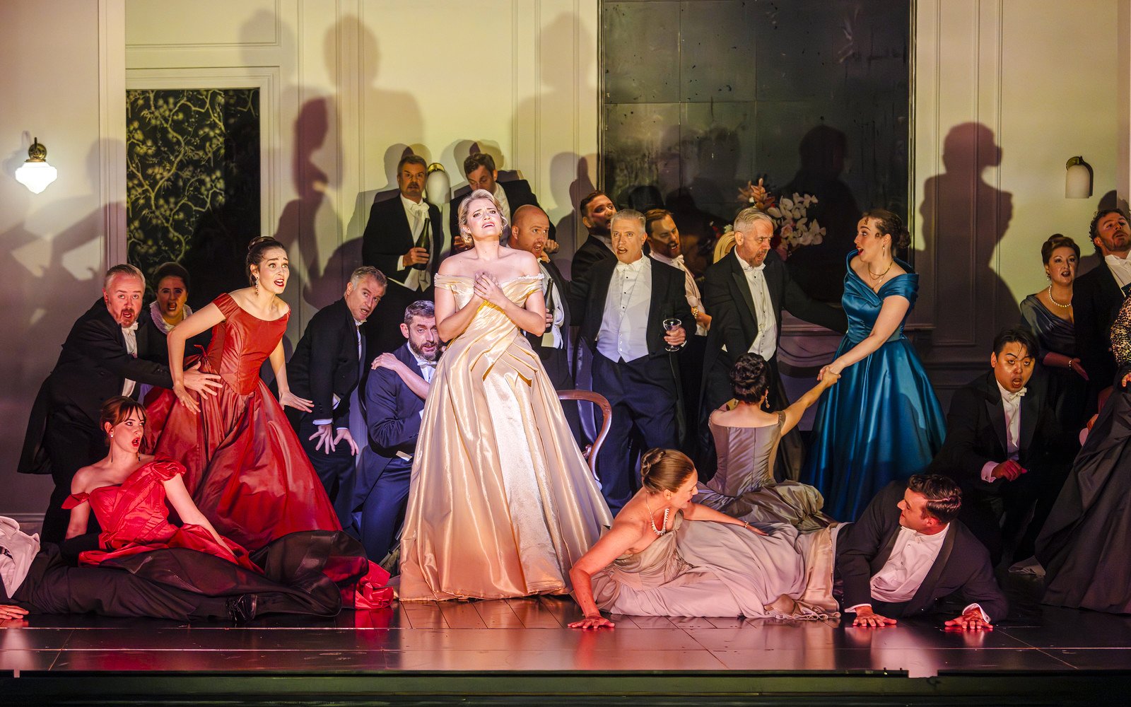 Opera performance scene from La Traviata with singers in elegant attire.