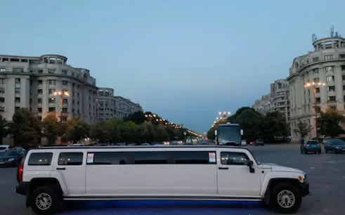 Limousine parked on a Bucharest street with historic buildings in the background.