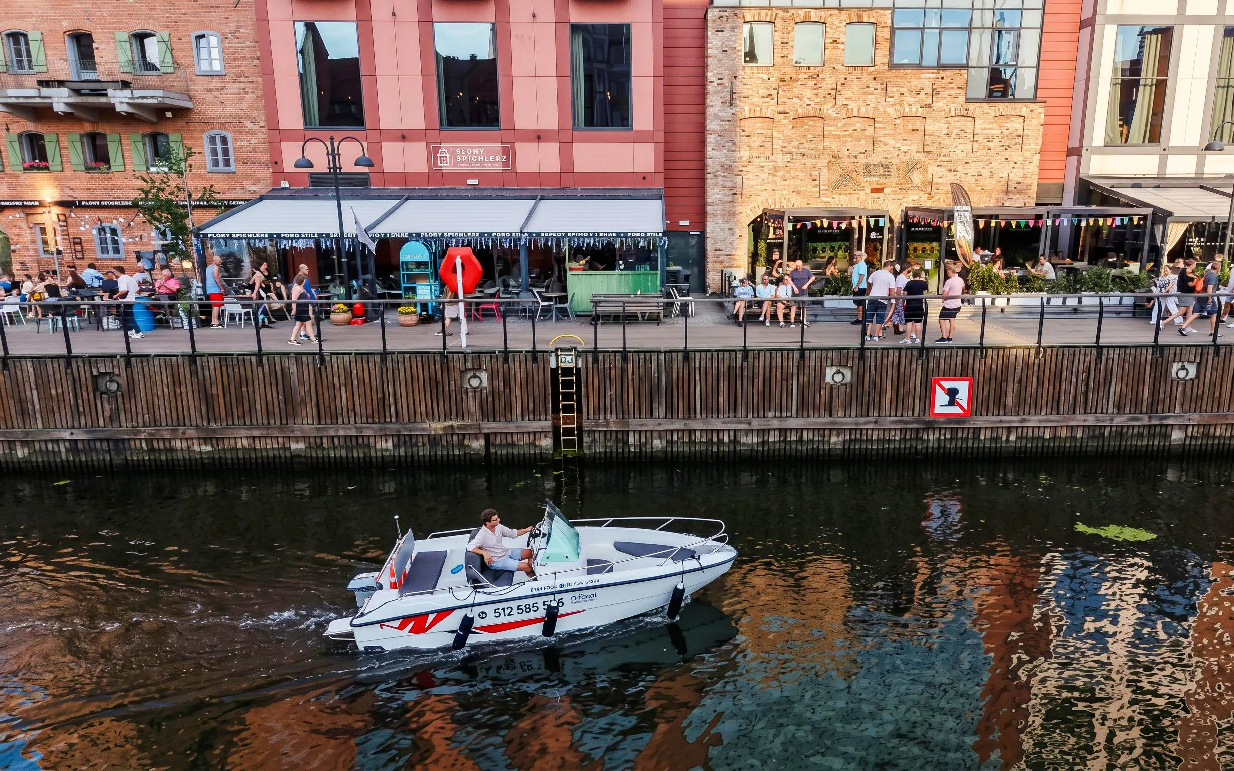 Guests navigating a self-drive electric boat along the waterfront in Gdansk.