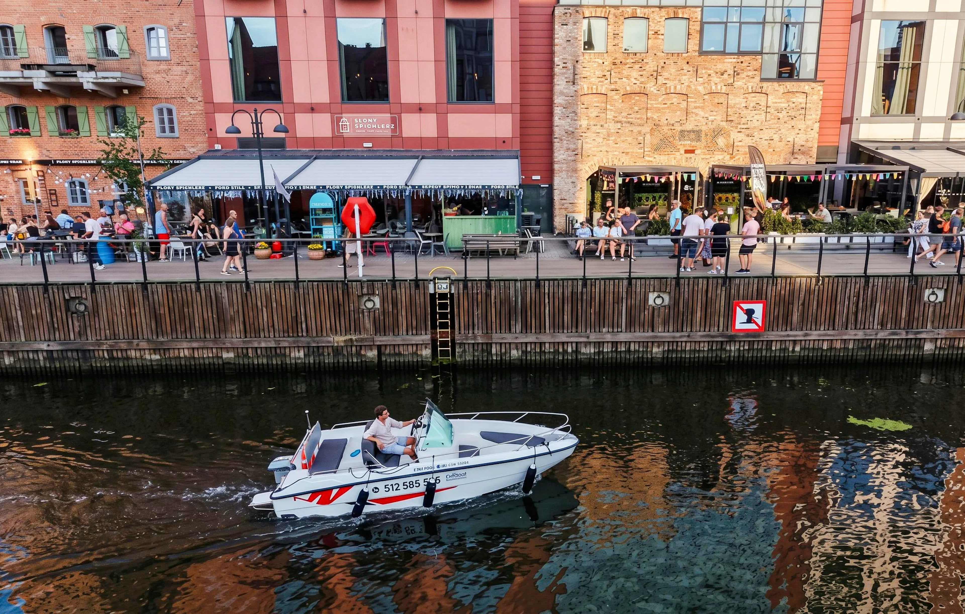 Guests navigating a self-drive electric boat along the waterfront in Gdansk.