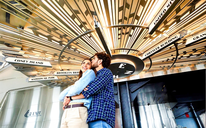 Couple embracing under the giant compass at the Empire State Building, NYC.