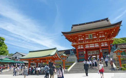 Visitors at Hase-dera Temple entrance in Kamakura, Japan, under a clear blue sky.