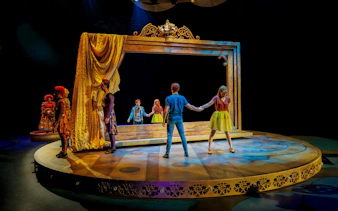 Performers on stage at CARO Theatre Show, Efteling Amsterdam, with a large ornate frame.