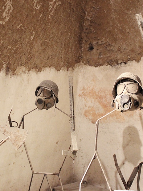 Naples Underground display of metal figures with military helmets and gas masks.