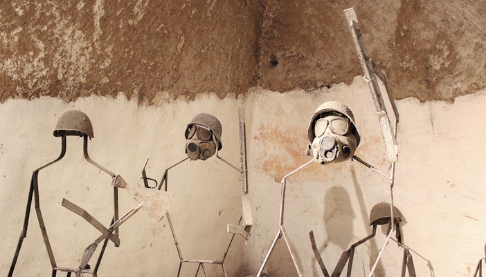 Naples Underground tour showcasing historical military gear in ancient tunnels.