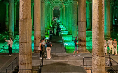 Tourists exploring the illuminated Basilica Cistern in Istanbul during an Old City Walking tour.