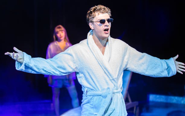 Performer in a robe and sunglasses on stage during Cruel Intentions: The 90's Musical.