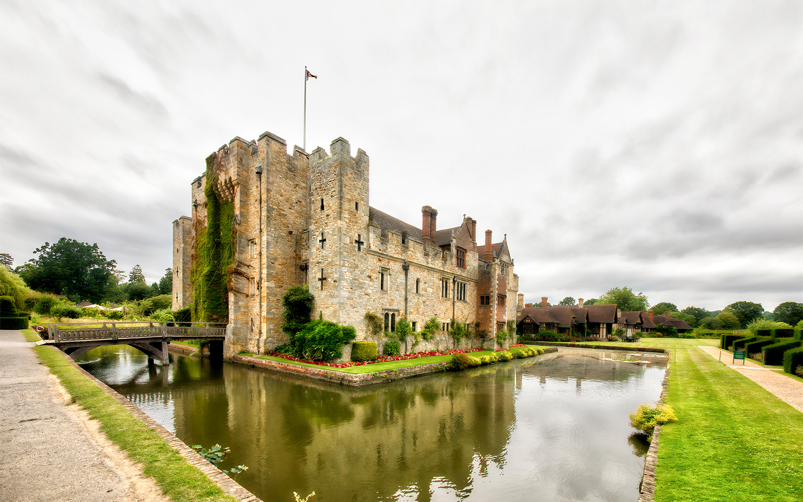 Hever Castle in Kent, England, surrounded by lush gardens and a tranquil moat.