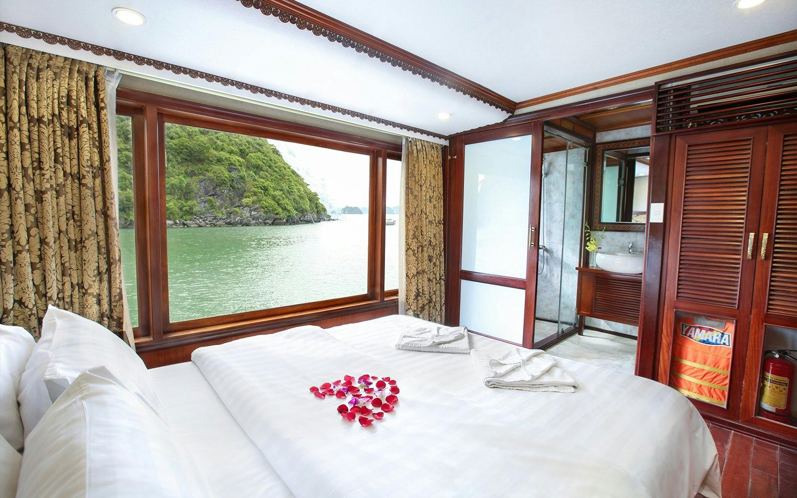 Cruise cabin with large window view of Halong Bay, Vietnam.