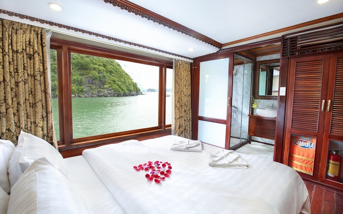 Cruise cabin with large window view of Halong Bay, Vietnam.