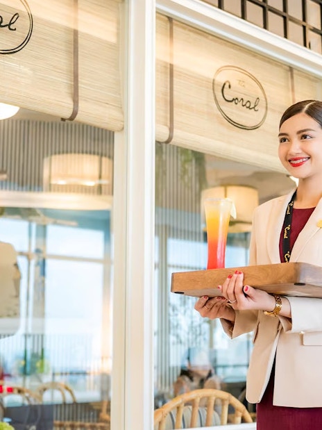 VIP lounge service at Donmuang Airport with staff serving a drink.