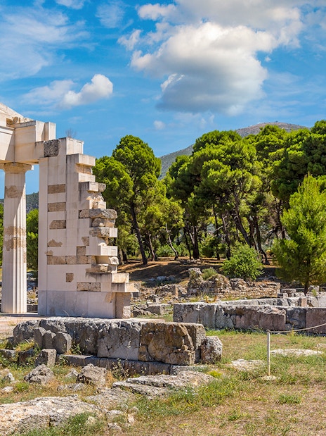 Epidaurus Ancient Theatre ruins with surrounding greenery and blue sky.