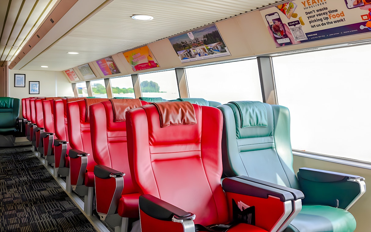 Ferry interior with red and green seats on the Singapore to Bintan Resorts route.