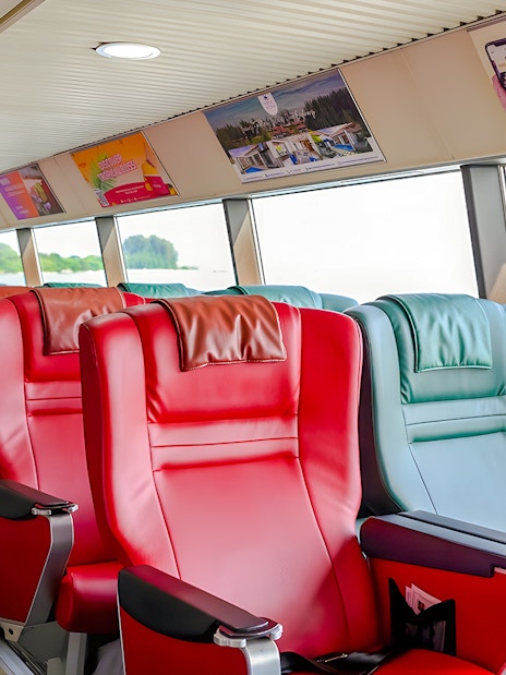 Ferry interior with red and green seats on the Singapore to Bintan Resorts route.