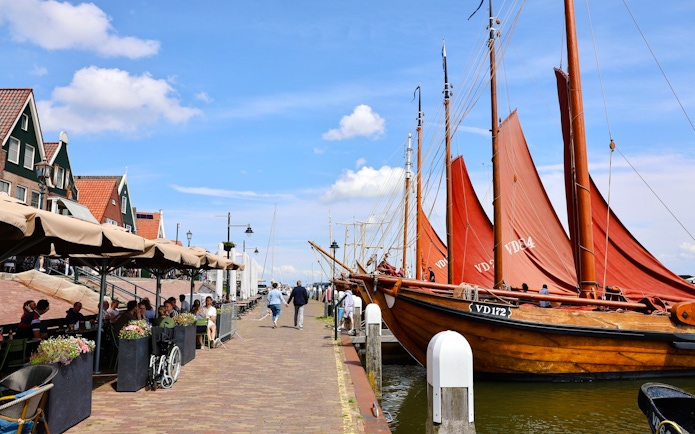 Volendam harbor with traditional boats and charming street cafes.