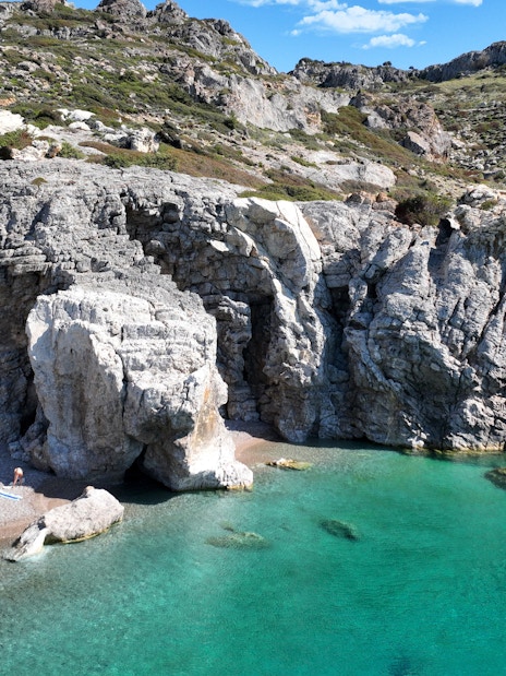 Traganou Caves with rocky cliffs and turquoise water, Rhodes, Greece.