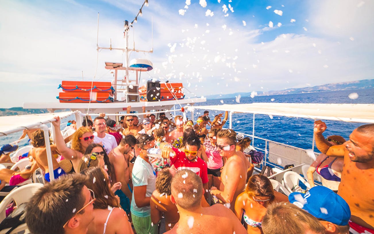 Group enjoying a lively party on a cruise to Rhenia and Little Venice, Mykonos.