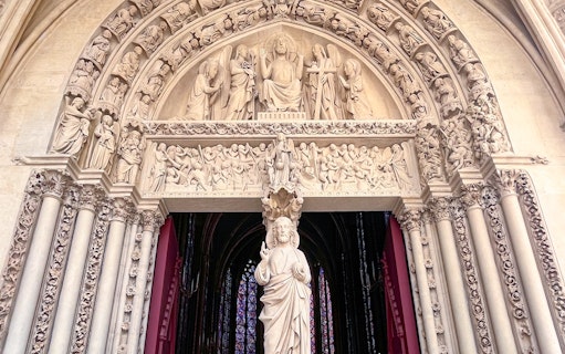 Sculpted entrance of Sainte Chapelle with intricate religious carvings, Paris.
