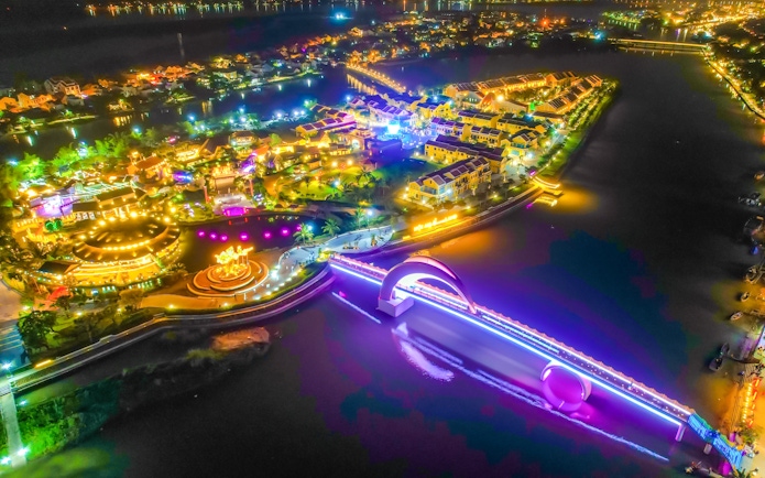 Hoi An Memories Show aerial view with illuminated bridge and vibrant lights reflecting on the river.