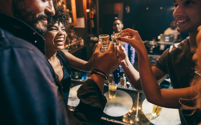 Group enjoying drinks at a bar during Busan pub crawl.