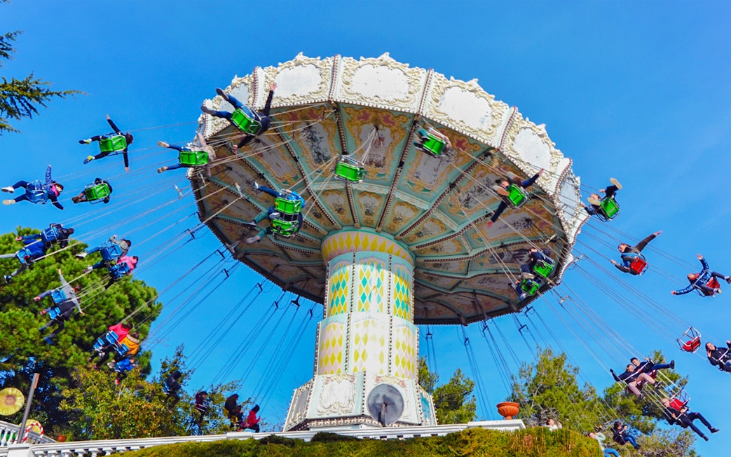 Riders on the Devil Ride swing carousel at Tibidabo Amusement Park, Barcelona.