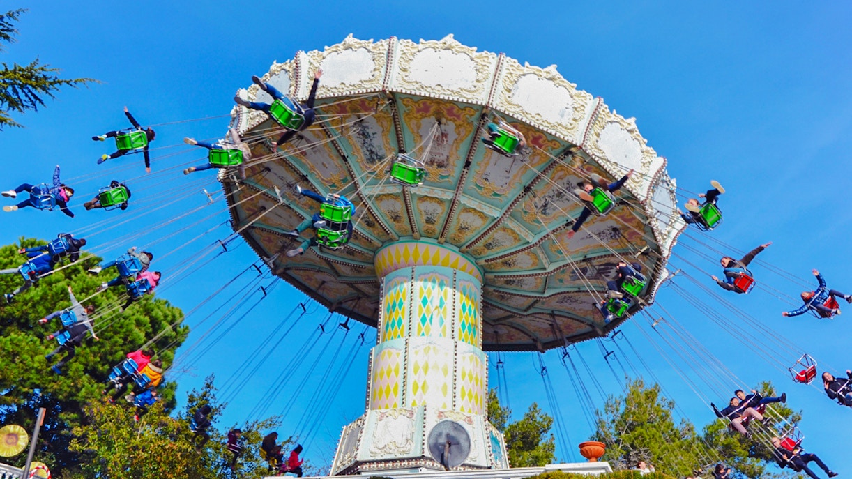 Riders on the Devil Ride swing carousel at Tibidabo Amusement Park, Barcelona.