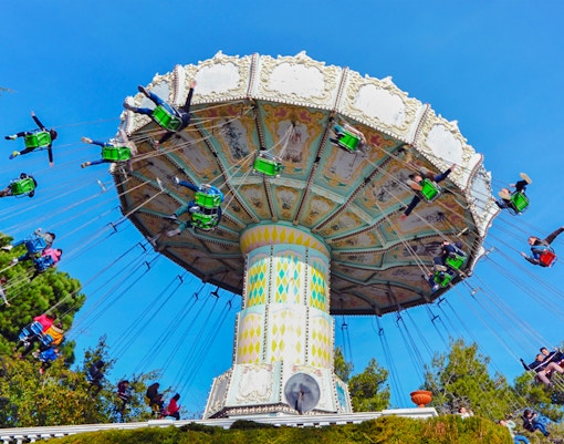 Riders on the Devil Ride swing carousel at Tibidabo Amusement Park, Barcelona.