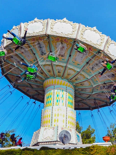 Riders on the Devil Ride swing carousel at Tibidabo Amusement Park, Barcelona.