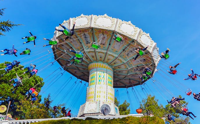Riders on the Devil Ride swing carousel at Tibidabo Amusement Park, Barcelona.